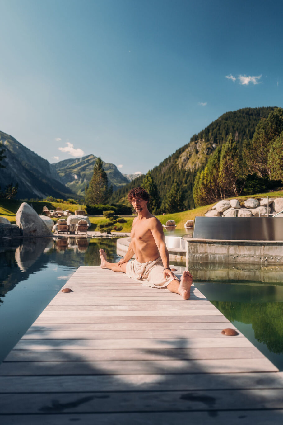 Mann im Spagat auf dem Steg am Quellteich im Jungbrunn